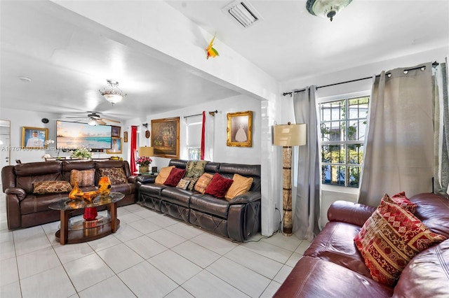 living room with light tile patterned flooring, visible vents, and a ceiling fan