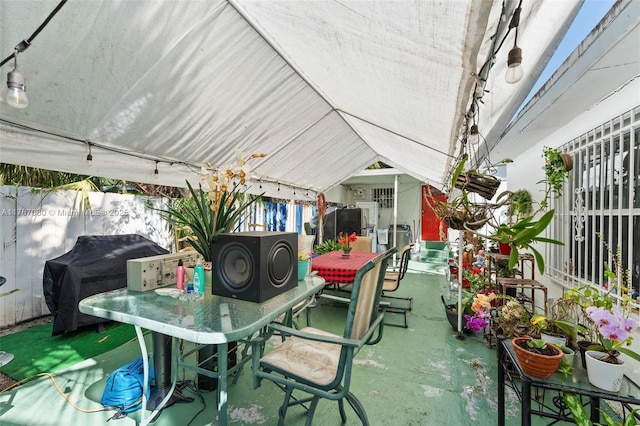 view of patio / terrace with outdoor dining area, a grill, and fence