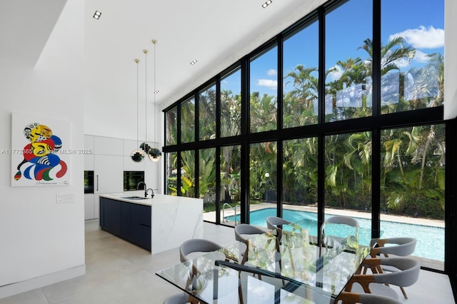 2421 NE 199th St, Miami, FL 33180 - living area featuring a high ceiling, plenty of natural light, and a wall of windows
