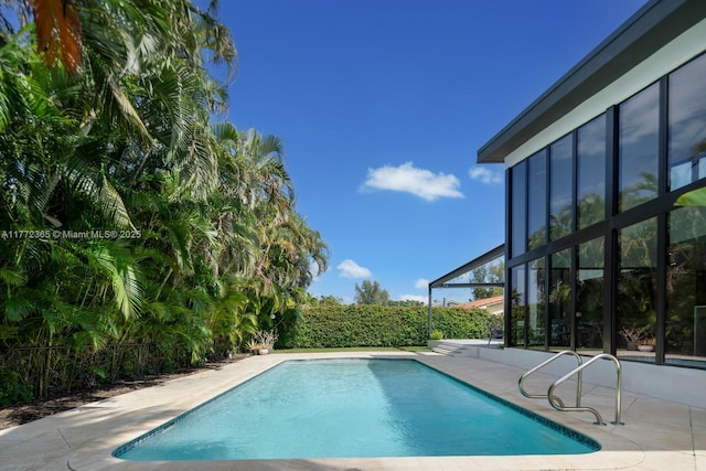 2421 NE 199th St, Miami, FL 33180 - view of swimming pool featuring a fenced in pool, glass enclosure, and a patio