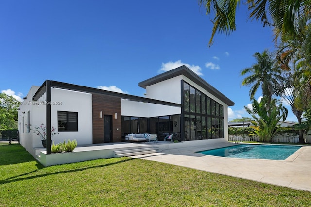 2421 NE 199th St, Miami, FL 33180 - rear view of property featuring stucco siding, an outdoor living space, a fenced in pool, a patio area, and a lawn