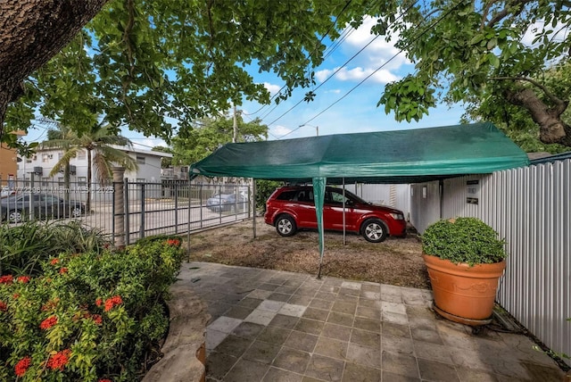 view of vehicle parking with a carport and fence private yard