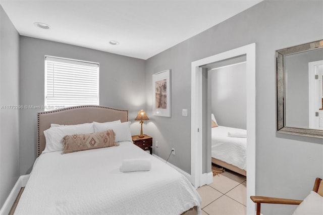 bedroom with baseboards and light tile patterned flooring