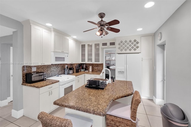 kitchen with a toaster, backsplash, white appliances, ceiling fan, and light tile patterned floors