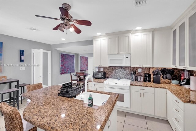 kitchen with visible vents, ceiling fan, white appliances, and light tile patterned floors