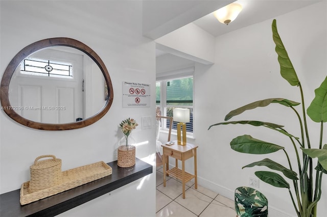 hall with baseboards and light tile patterned floors