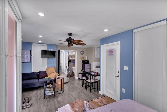 living area with baseboards, a ceiling fan, wood finished floors, and recessed lighting