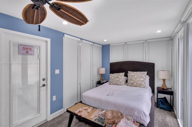 bedroom featuring baseboards, wood finished floors, recessed lighting, and a decorative wall