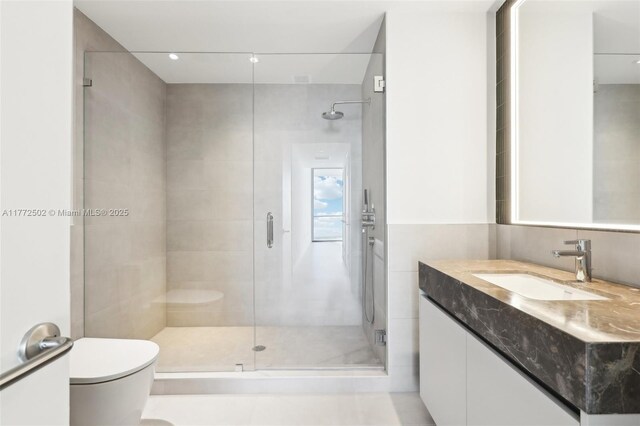 full bathroom featuring a shower stall, toilet, and vanity