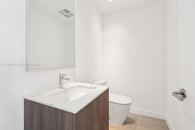 half bath with baseboards, toilet, vanity, and visible vents