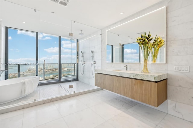 full bath featuring plenty of natural light, vanity, a water view, and a stall shower
