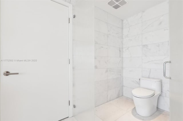 bathroom featuring toilet, walk in shower, and visible vents