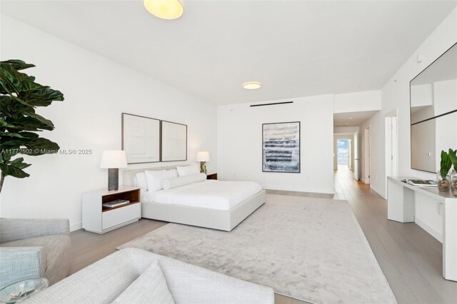 bedroom featuring light wood finished floors and baseboards