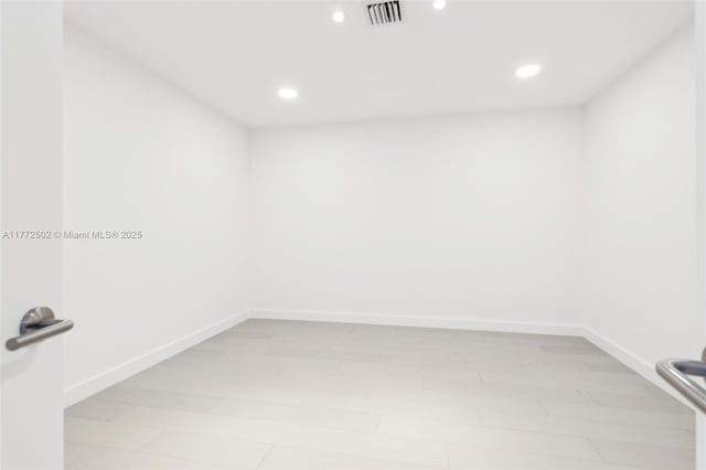 unfurnished room featuring baseboards, visible vents, and recessed lighting