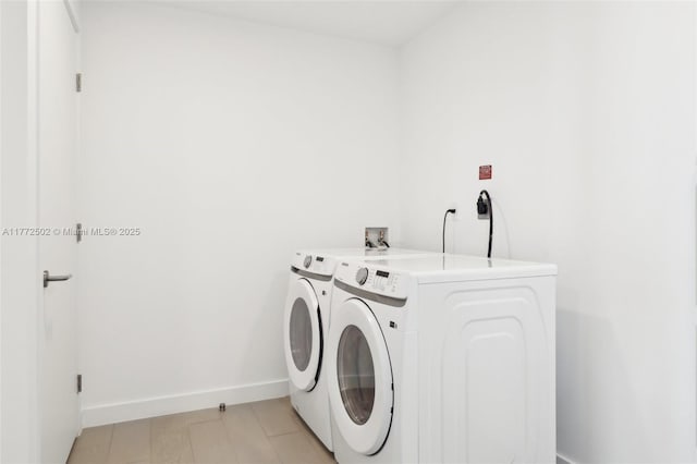 laundry room featuring washing machine and clothes dryer, baseboards, and laundry area