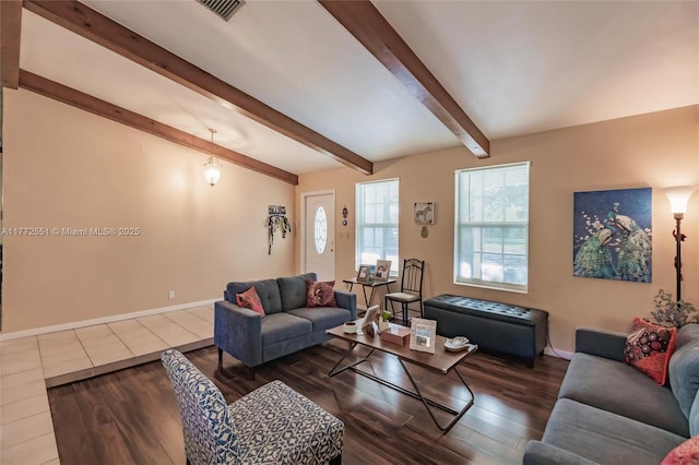 living area featuring baseboards, visible vents, wood finished floors, and beam ceiling