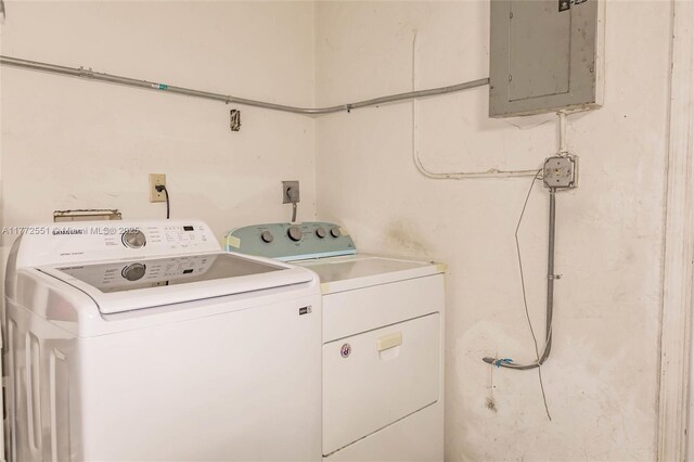 washroom featuring electric panel, washing machine and dryer, and laundry area