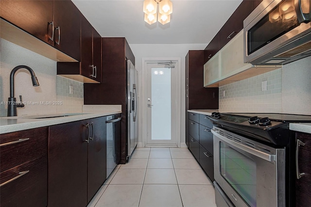 1030 9th St Unit 203, Miami Beach, FL 33139 - kitchen with stainless steel appliances, light countertops, backsplash, and a chandelier