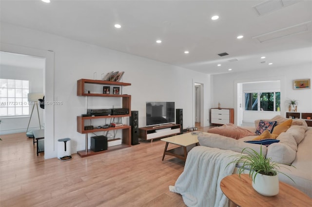 living area with a healthy amount of sunlight, light wood finished floors, visible vents, and recessed lighting