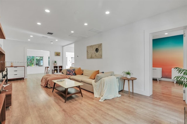living room featuring light wood finished floors, baseboards, visible vents, and recessed lighting