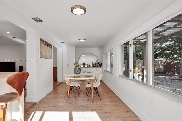 dining space with light wood-style floors, baseboards, and visible vents