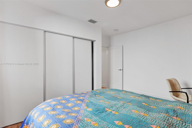 carpeted bedroom featuring a closet, baseboards, and visible vents