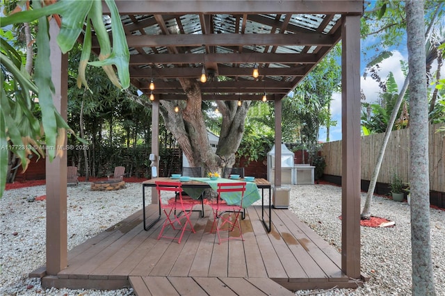 deck with an outdoor fire pit, outdoor dining space, a fenced backyard, and a pergola