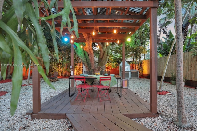 wooden deck with a fenced backyard, outdoor dining space, and a pergola
