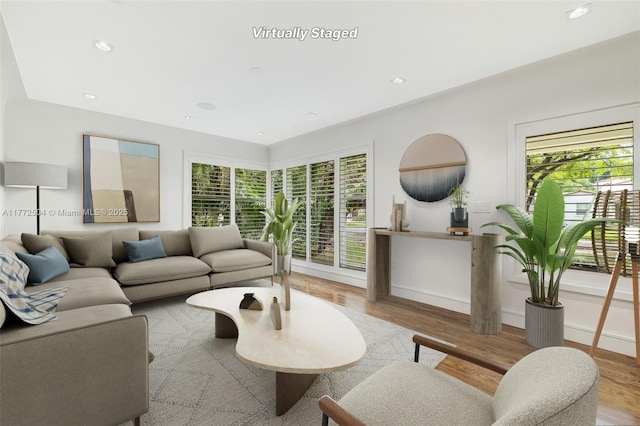 living room with a wealth of natural light, wood finished floors, and recessed lighting