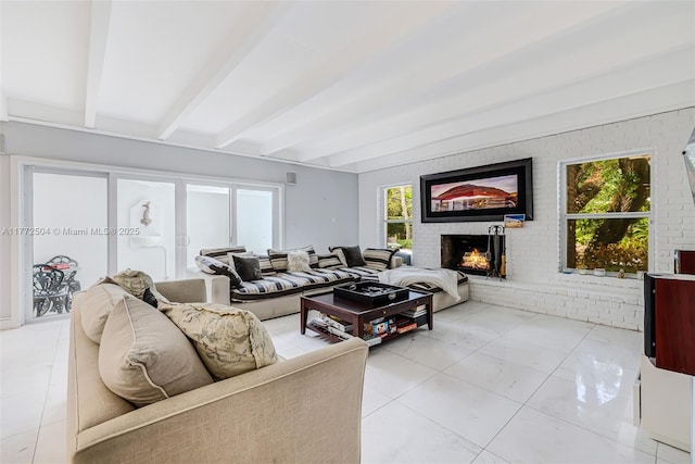 living room with beamed ceiling, brick wall, and a brick fireplace