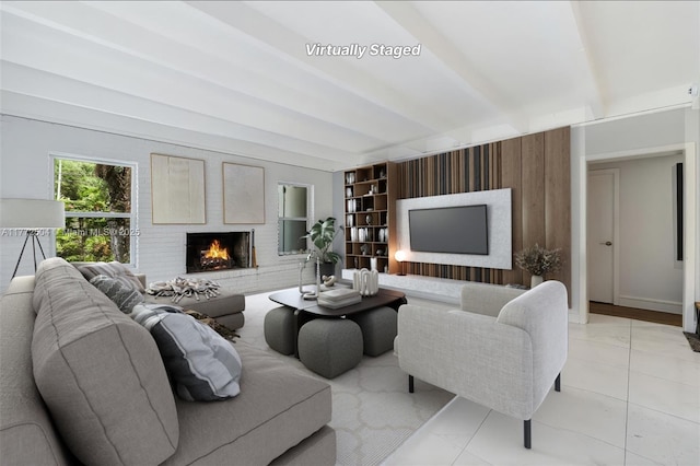 living area with baseboards, beam ceiling, light tile patterned floors, and a brick fireplace