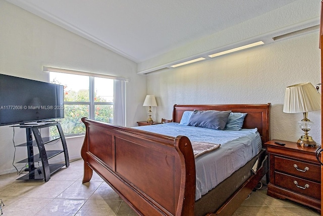 bedroom with vaulted ceiling and light tile patterned floors
