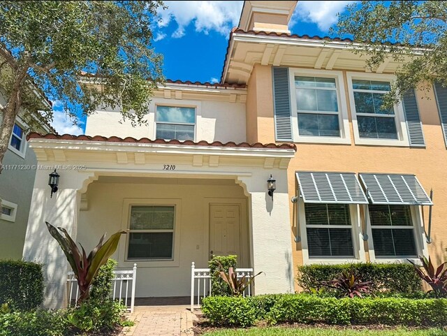 3210 NW 126th Ave Unit 3210, Sunrise, FL 33323 - view of front of home with a tile roof, stucco siding, a chimney, and fence