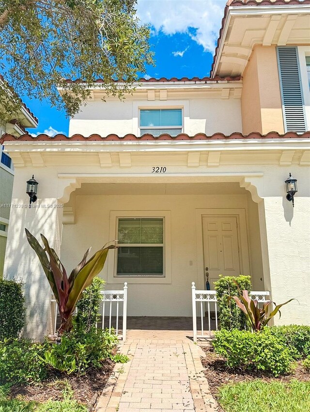 3210 NW 126th Ave Unit 3210, Sunrise, FL 33323 - view of exterior entry featuring a tiled roof, stucco siding, and covered porch