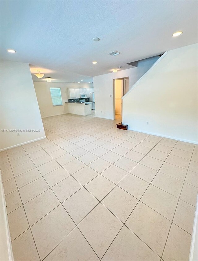 3210 NW 126th Ave Unit 3210, Sunrise, FL 33323 - unfurnished living room featuring recessed lighting, light tile patterned flooring, baseboards, stairs, and a textured ceiling