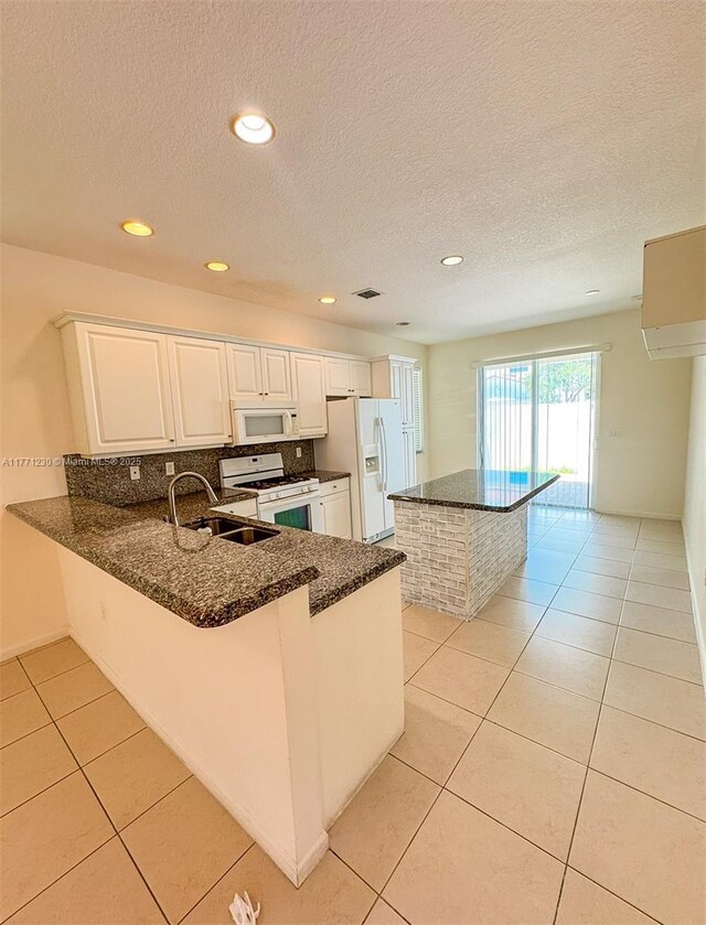 3210 NW 126th Ave Unit 3210, Sunrise, FL 33323 - kitchen with white appliances, a sink, dark stone countertops, light tile patterned floors, and a textured ceiling