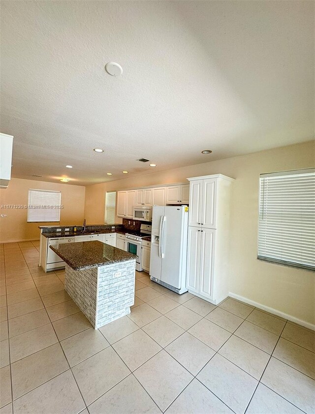 3210 NW 126th Ave Unit 3210, Sunrise, FL 33323 - kitchen with white appliances, light tile patterned flooring, a sink, dark stone counters, and recessed lighting