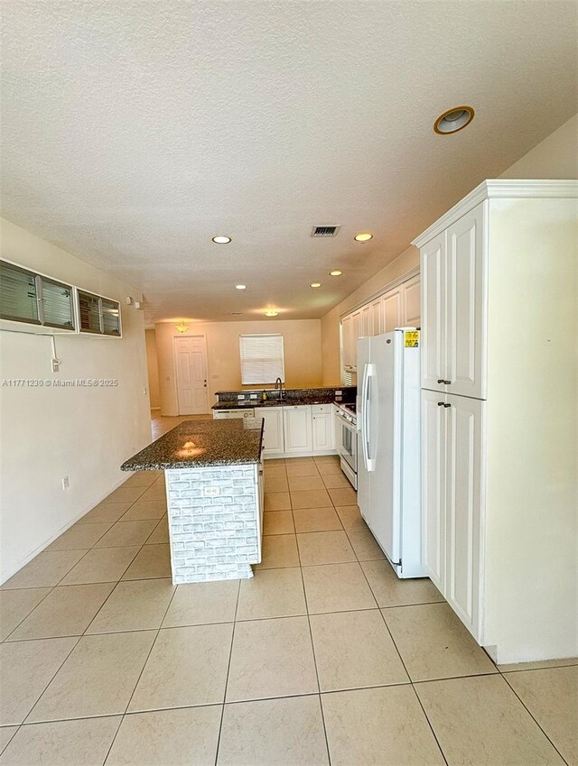3210 NW 126th Ave Unit 3210, Sunrise, FL 33323 - kitchen with freestanding refrigerator, stove, a sink, light tile patterned floors, and dark stone countertops