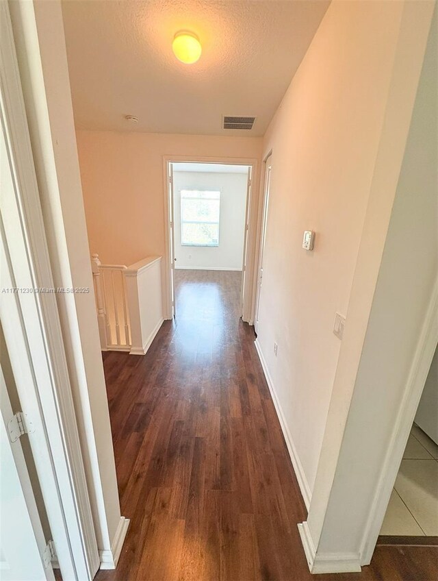 3210 NW 126th Ave Unit 3210, Sunrise, FL 33323 - corridor with an upstairs landing, dark wood finished floors, a textured ceiling, and baseboards