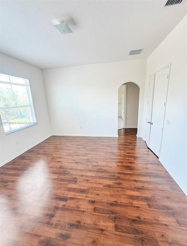 3210 NW 126th Ave Unit 3210, Sunrise, FL 33323 - unfurnished room with arched walkways, dark wood-style floors, and baseboards