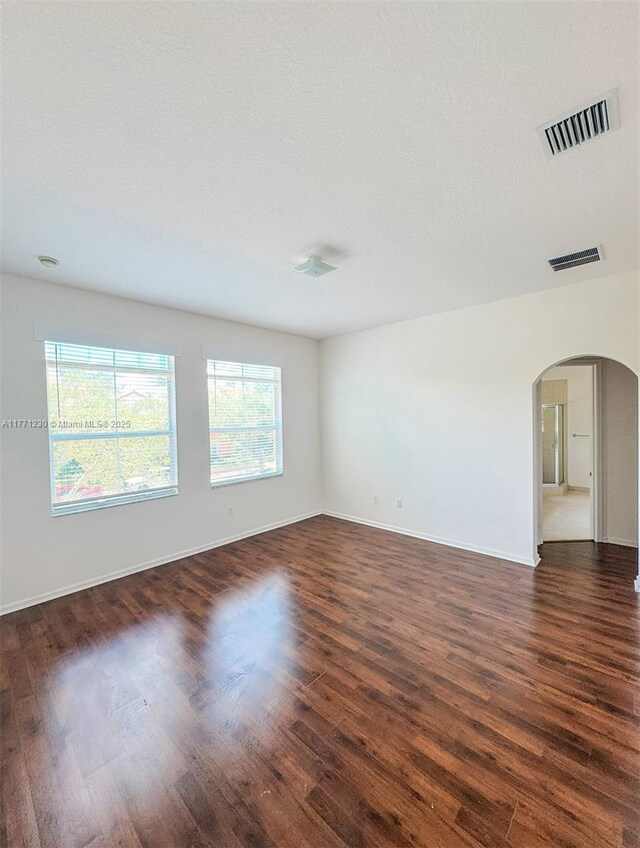 3210 NW 126th Ave Unit 3210, Sunrise, FL 33323 - spare room with arched walkways, dark wood-type flooring, and baseboards