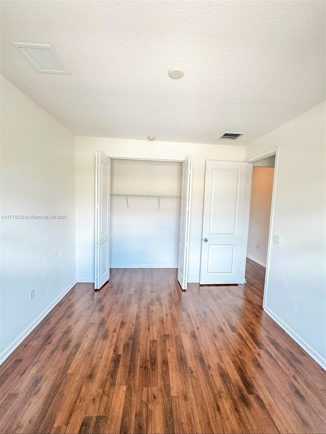 3210 NW 126th Ave Unit 3210, Sunrise, FL 33323 - unfurnished bedroom with wood finished floors, baseboards, and a closet
