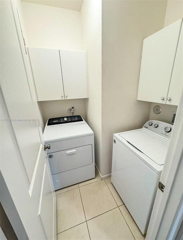 3210 NW 126th Ave Unit 3210, Sunrise, FL 33323 - washroom featuring separate washer and dryer, cabinet space, light tile patterned floors, and baseboards
