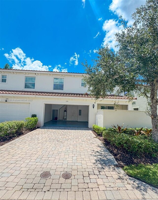 3210 NW 126th Ave Unit 3210, Sunrise, FL 33323 - view of property featuring decorative driveway, stucco siding, fence, and a tiled roof