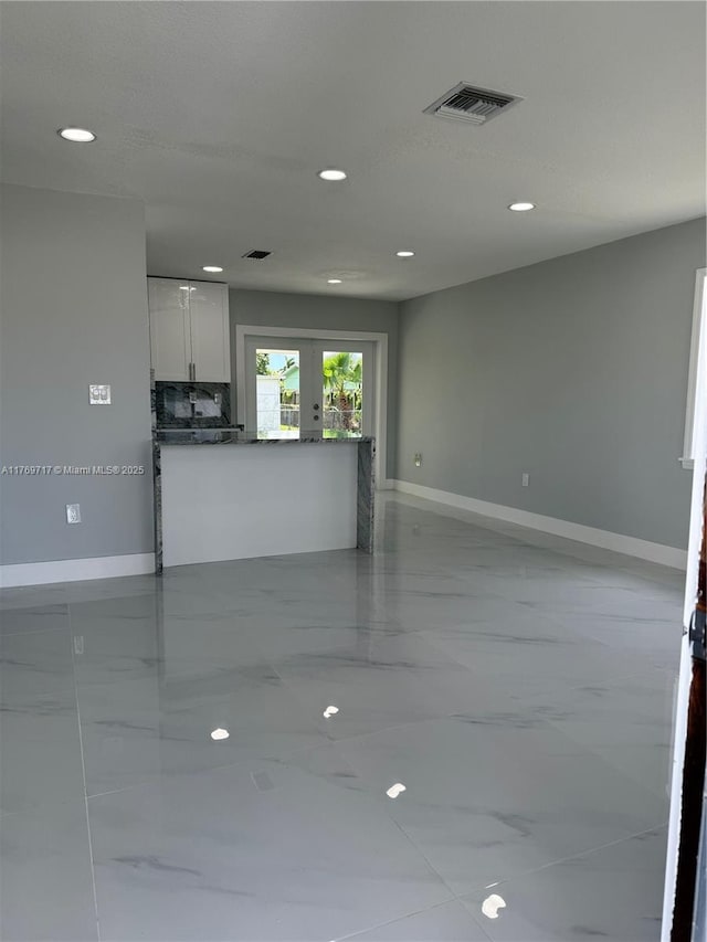 unfurnished living room with visible vents, baseboards, marble finish floor, recessed lighting, and french doors