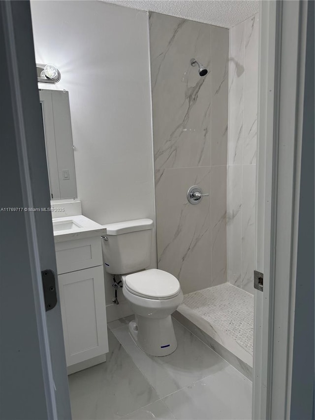 bathroom featuring marble finish floor, toilet, vanity, and a marble finish shower