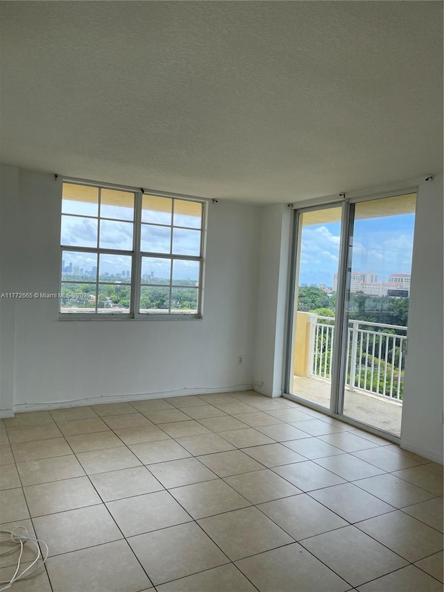 empty room with light tile patterned floors and a textured ceiling