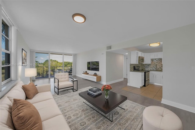 living area featuring baseboards, visible vents, and light wood finished floors