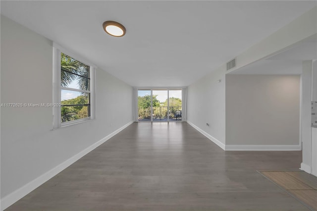 empty room with baseboards, wood finished floors, and visible vents