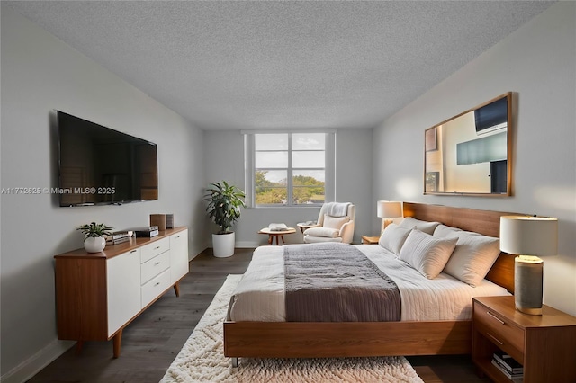 bedroom with dark wood-type flooring, a textured ceiling, and baseboards